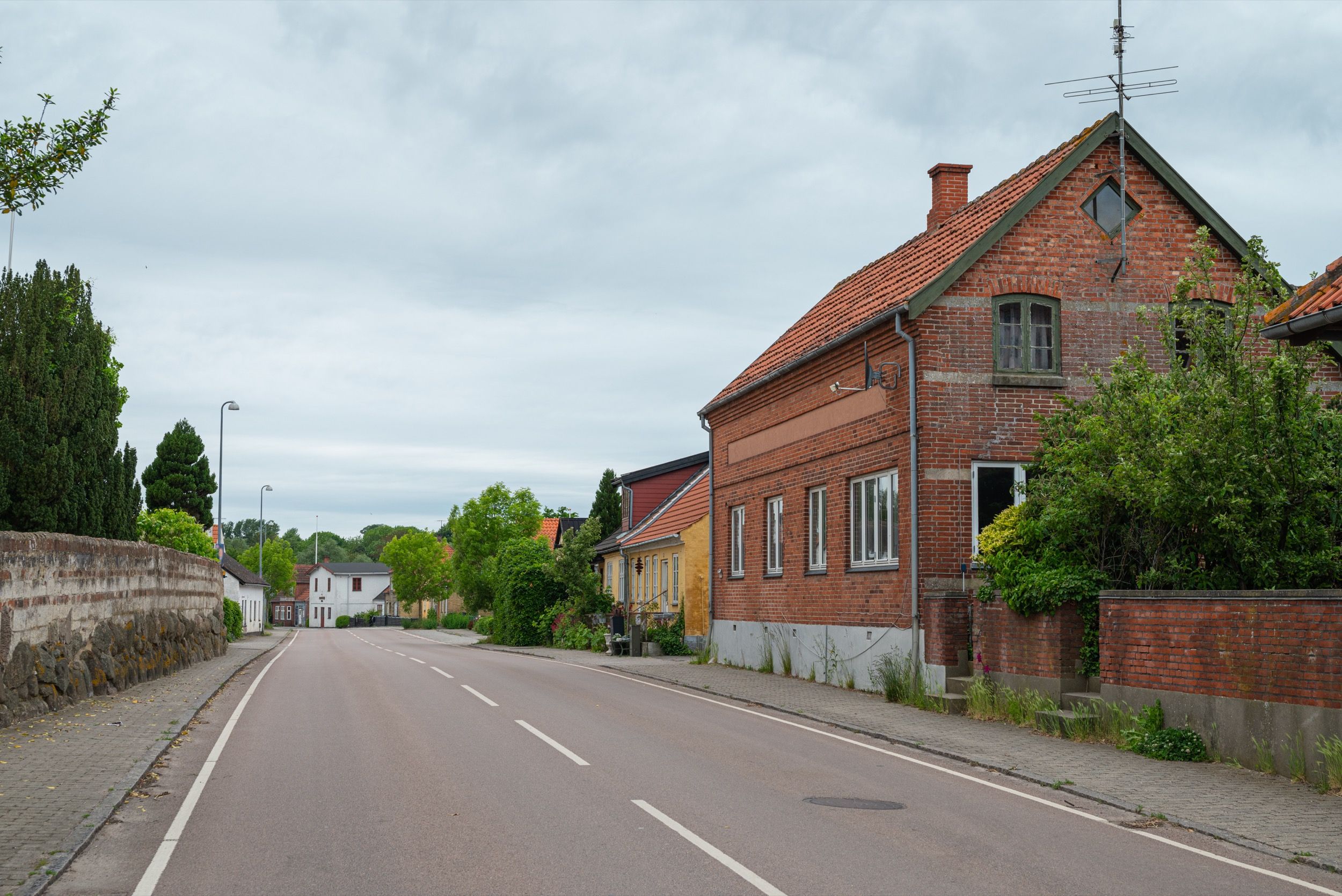 Die kleine Ortschaft Borre zeigt typische dänische Dorfarchitektur mit roten Backsteingebäuden entlang einer ruhigen Dorfstraße.