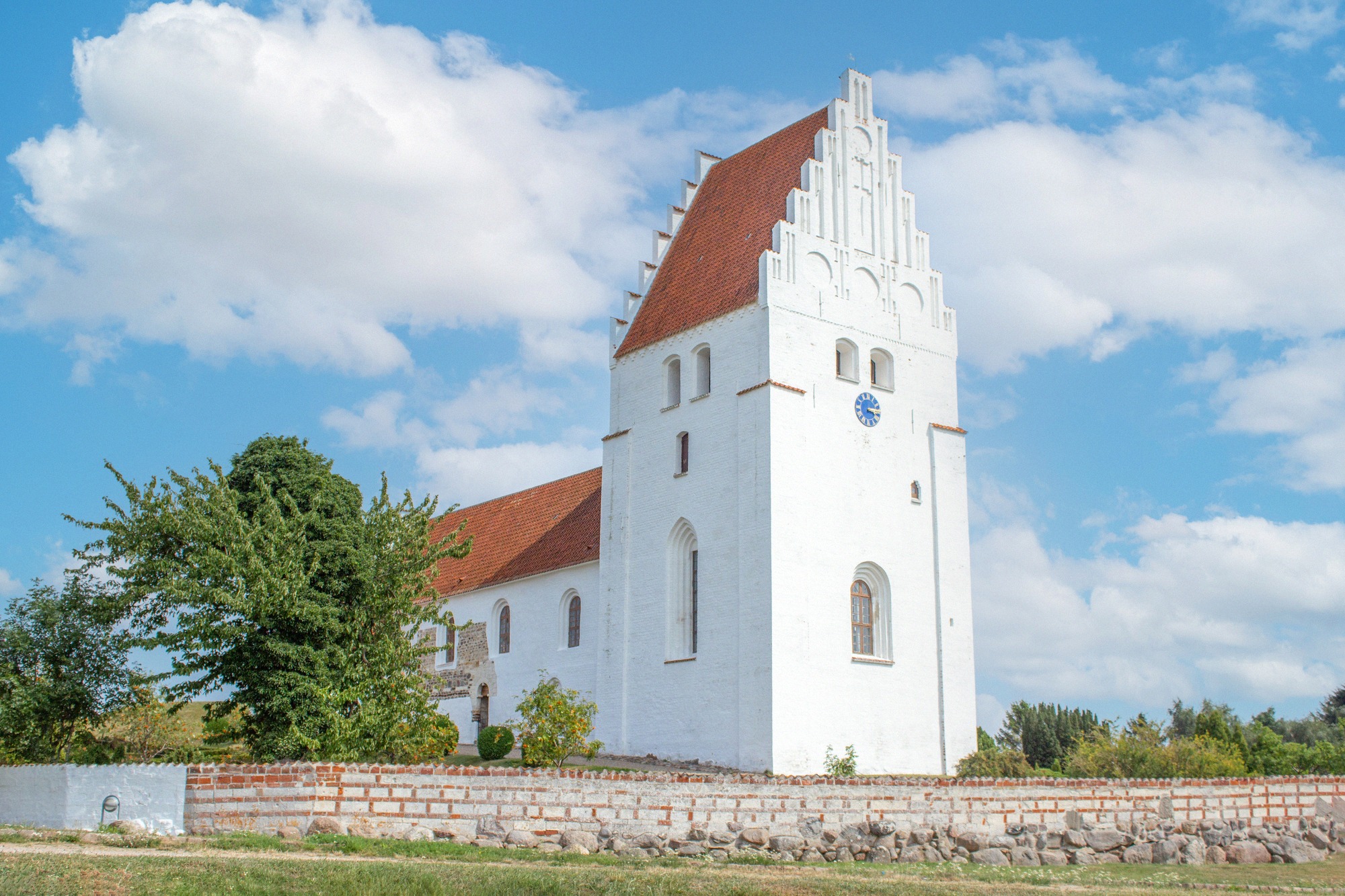 Elmelunde Kirke, which gave the Elmelunde Master his name. The white Elmelunde Kirke with pointed tower and red-tiled roofs